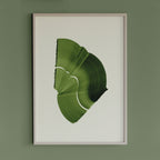 Leafy spring green abstract artwork in a thin white oak wooden frame on a sage green wall
