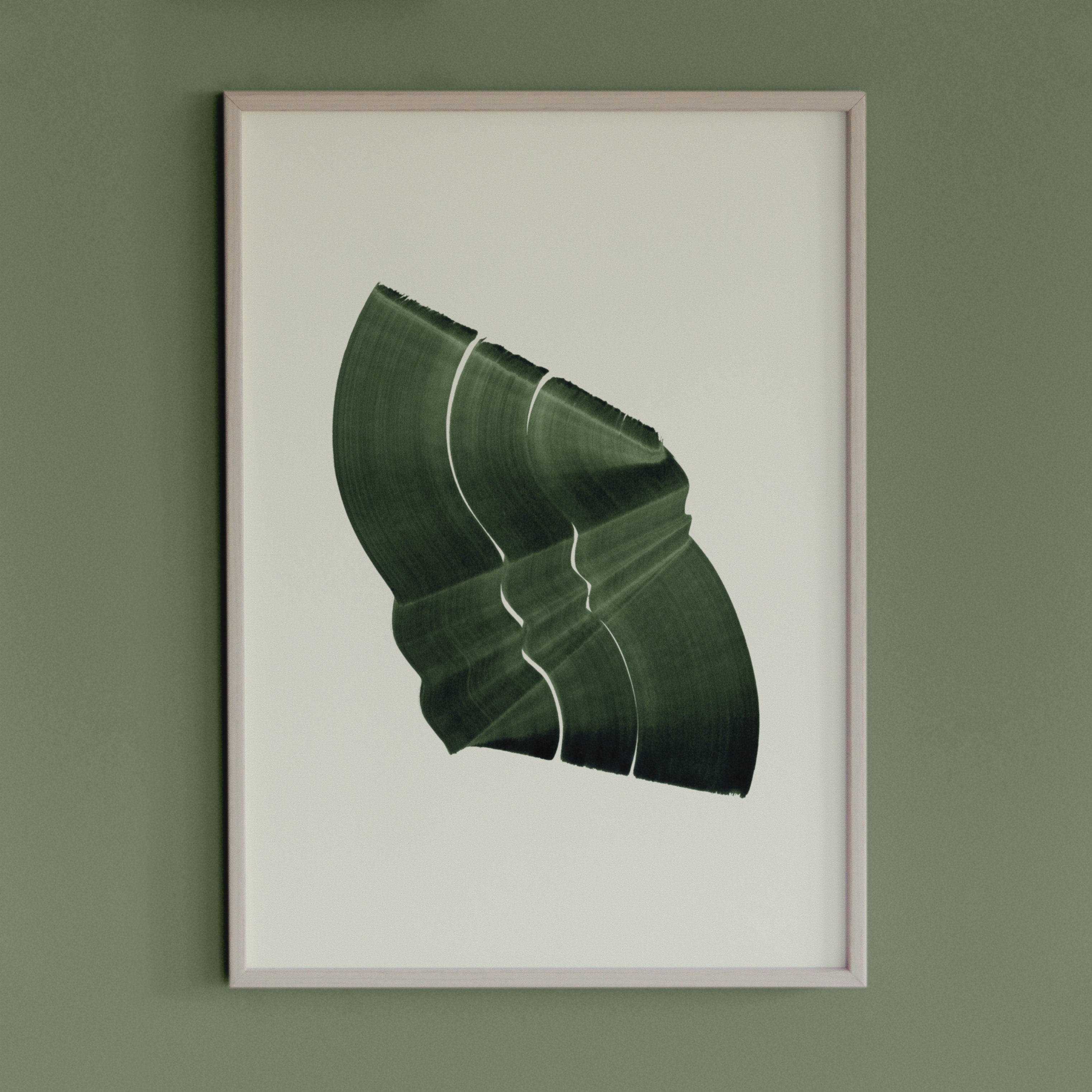 Dark leafy green abstract artwork in a thin white oak wooden frame on a sage green wall