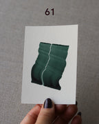 Hand holding sample of a green abstract art print with a green leaf-like design