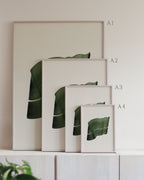 Set of framed green art prints with abstract leaf designs on a neutral background, showing in sizes A4, A3, A2 and A1