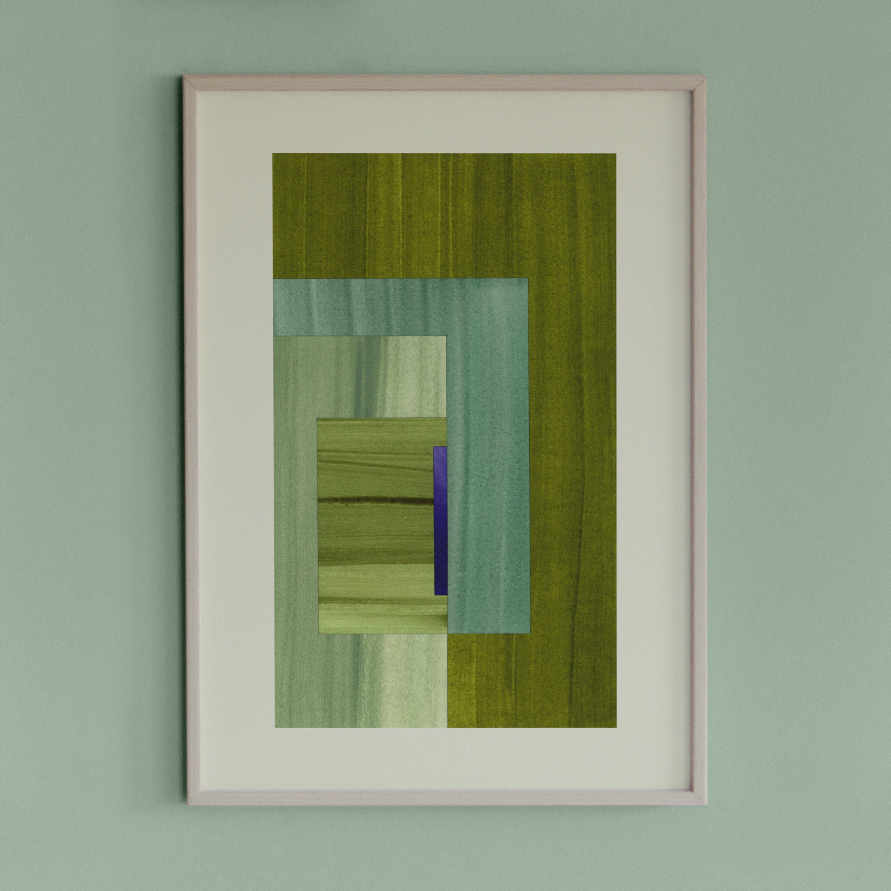 Framed geometric abstract art piece with green and blue colours on a light green wall.