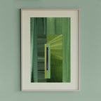 Framed geometric abstract art piece with grass green and blue colours on a light green wall.