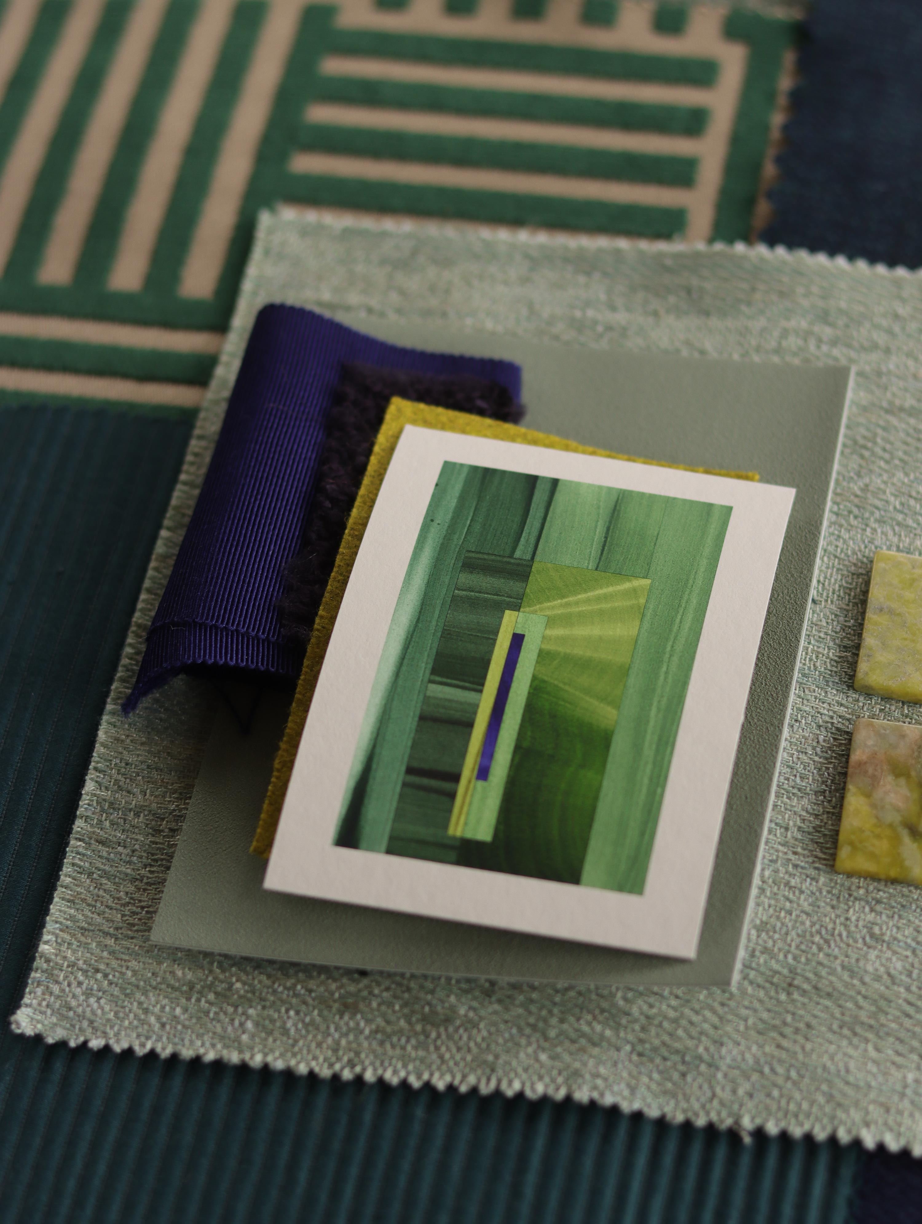Small geometric abstract art print sample with grass green and blue colours, laying on top of fabric swatches for colourful green interiors inspiration.