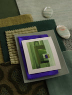 Small geometric abstract art print sample with grass green, mint green and blue colours, laying on top of fabric swatches for green interiors colour inspiration.