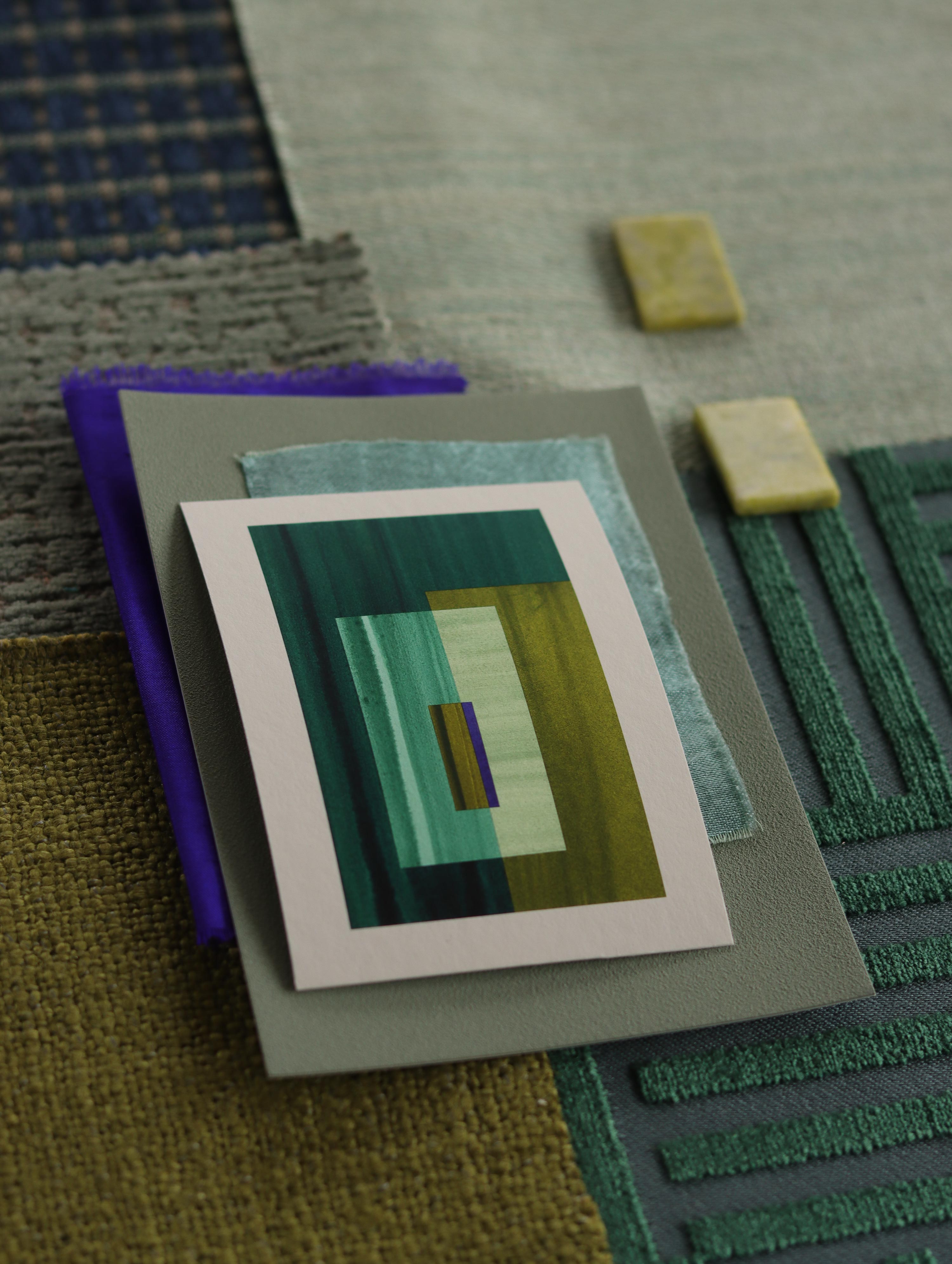 Small geometric abstract art print sample with turquoise, forest green and blue colours, laying on top of fabric swatches for green interiors colour inspiration.