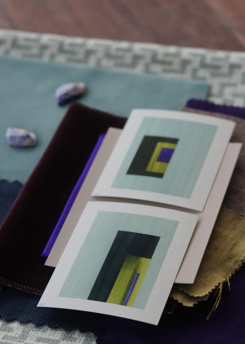 Blue, green and yellow geometric abstract art print samples with fabric swatches. Inspiration for teal and blue themed interior decor.