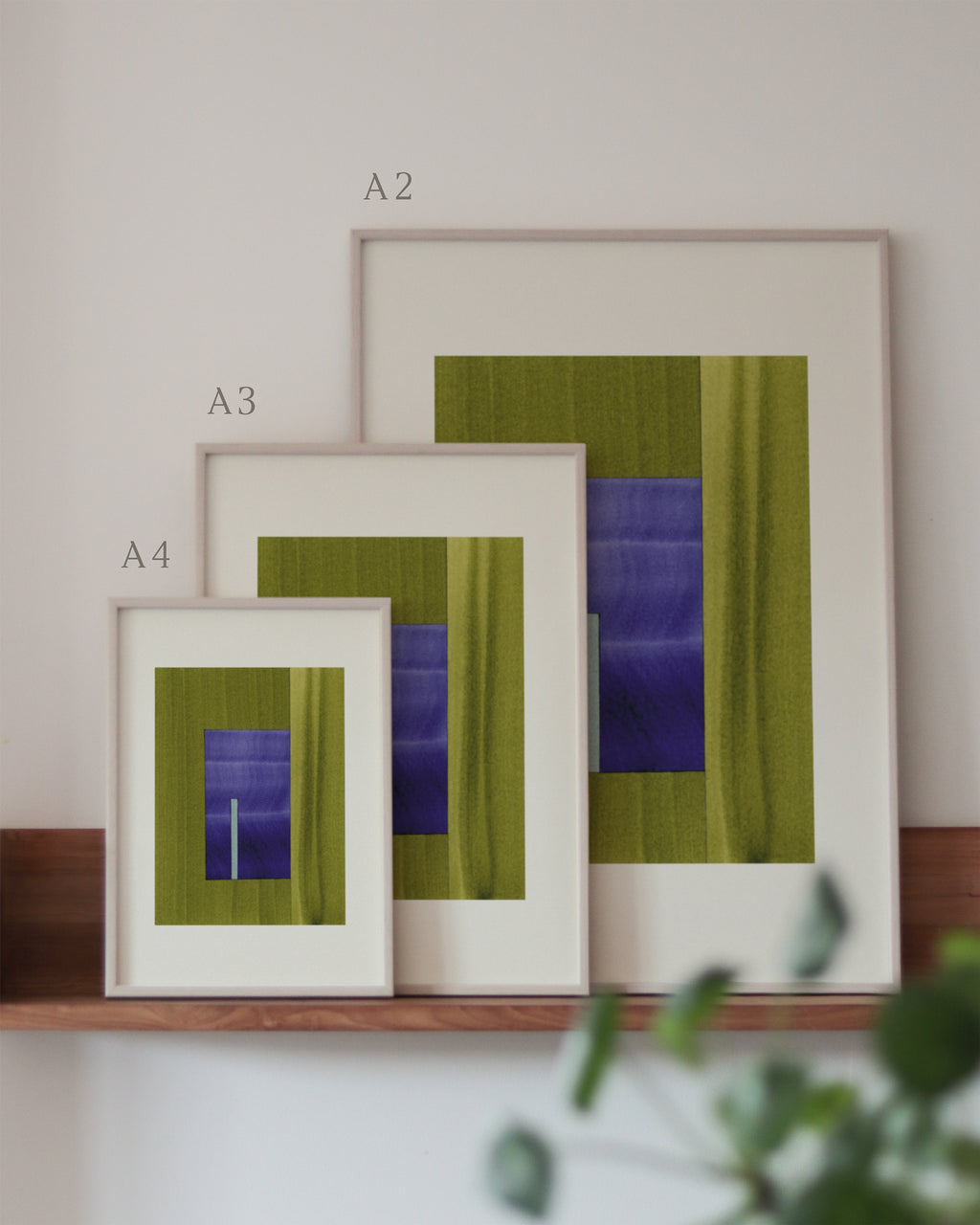 Set of green and blue framed geometric abstract art prints on a neutral background, showing in sizes A4, A3, and A2