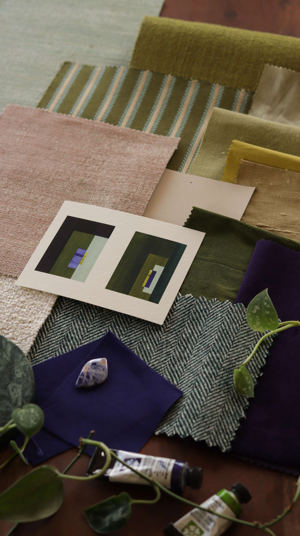 Blue, green and dark brown geometric abstract art print samples with fabric swatches. Inspiration for earthy green and pink themed interior decor.