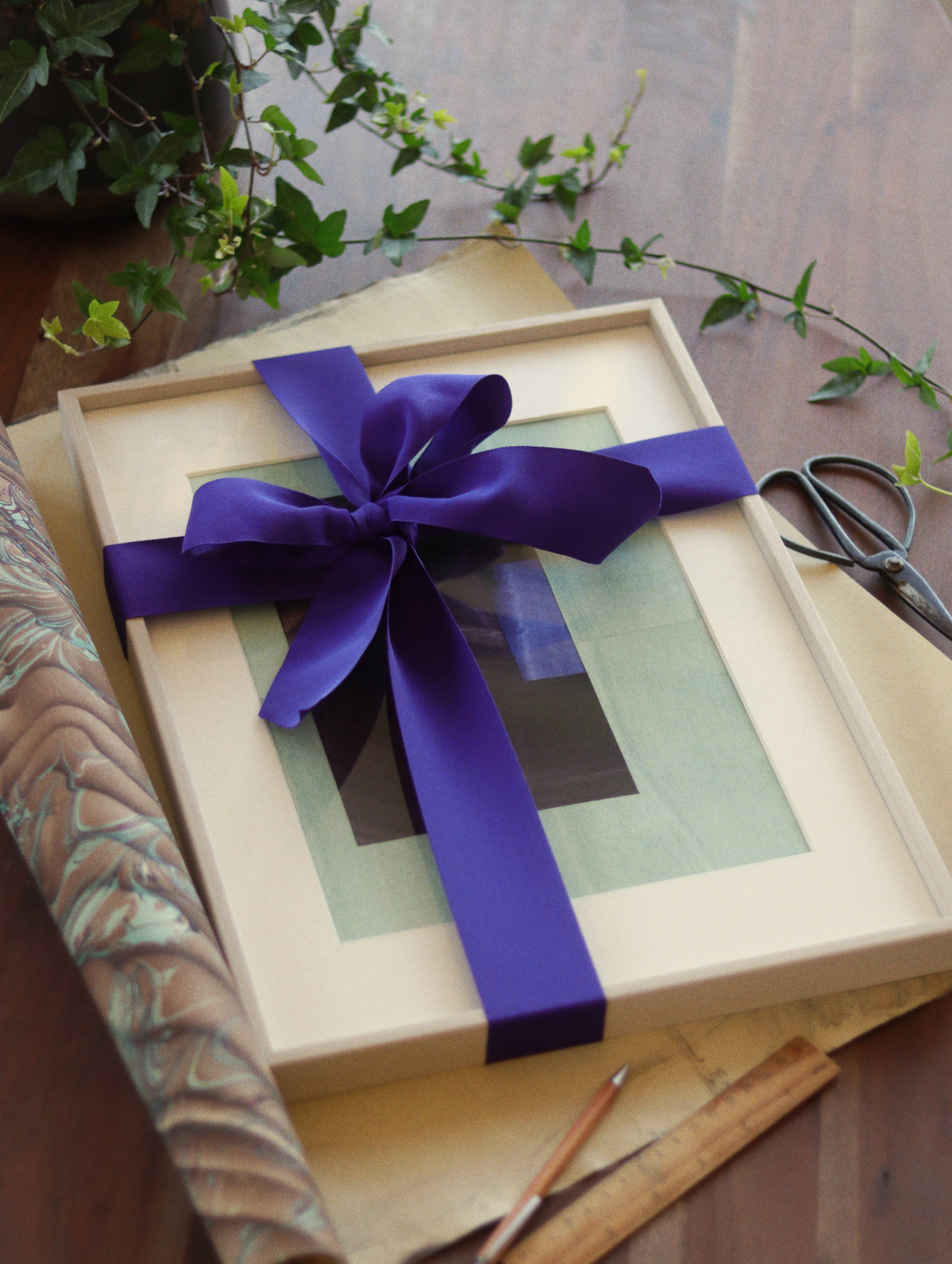 Picture frame wrapped in a bow as a visual for a gift card from Johanan Studio art