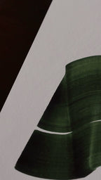 Slow close-up detail footage of a dark green abstract art print on fine art paper