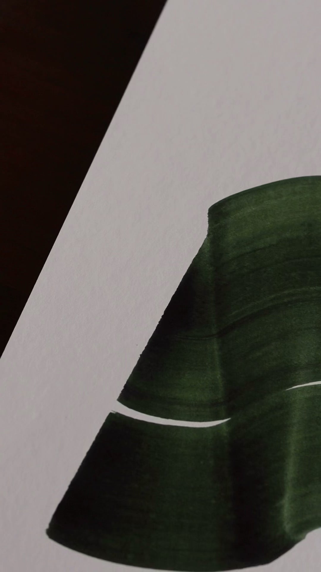 Slow close-up detail footage of a dark green abstract art print on fine art paper