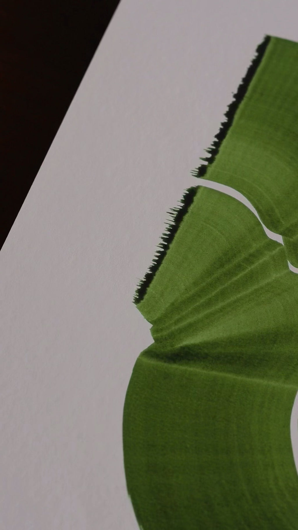 Slow close-up detail footage of a green abstract art print on fine art paper