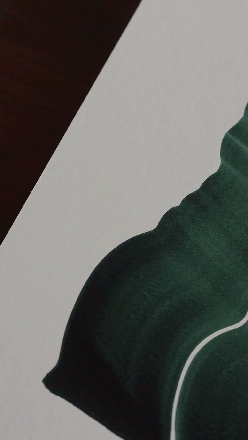 Slow close-up detail footage of a dark green abstract art print on fine art paper