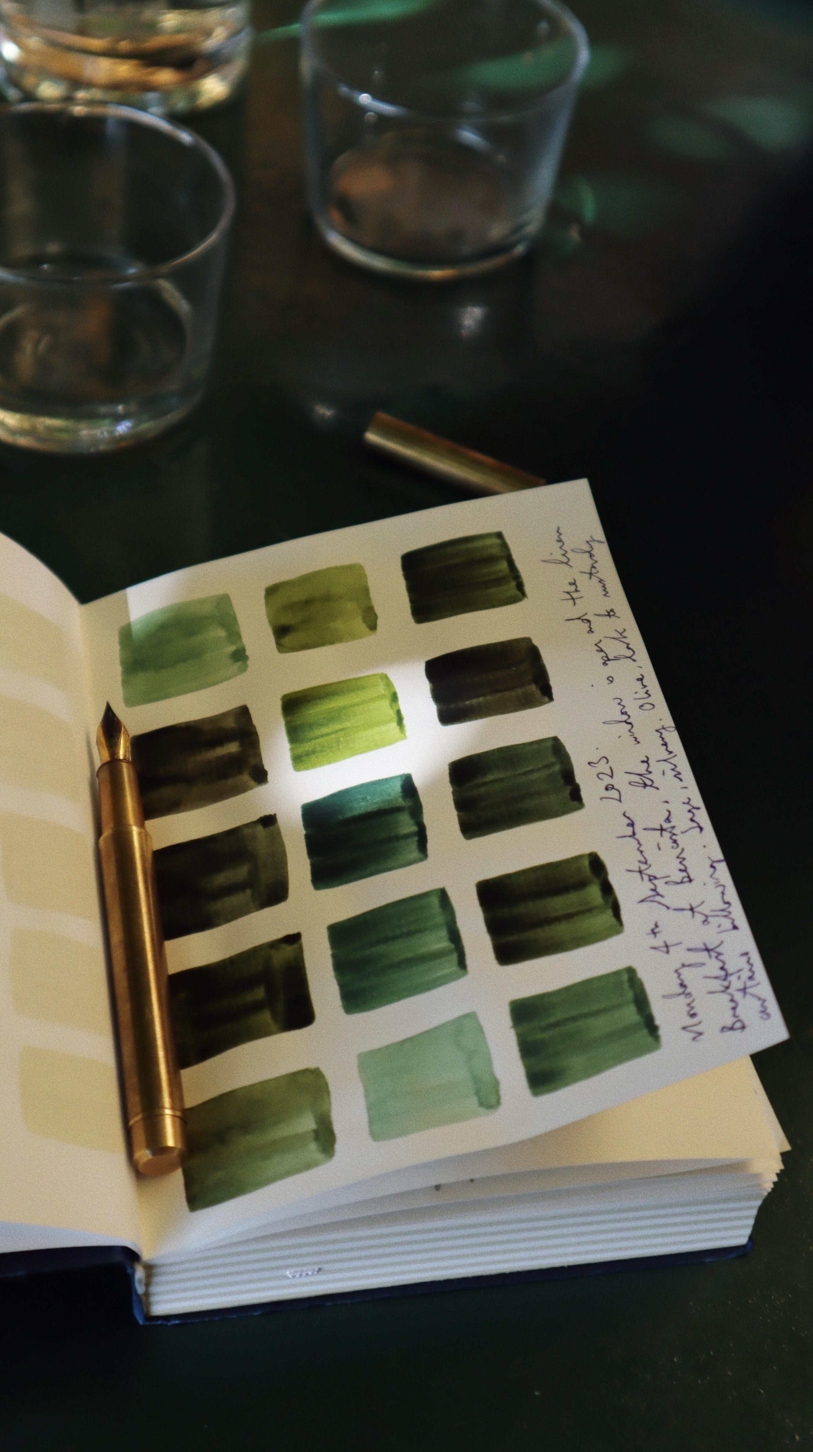 artist Aimee Johanan's open sketchbook with green paint swatches inspired by the greens surrounding the city of Florence, in the verdant hills